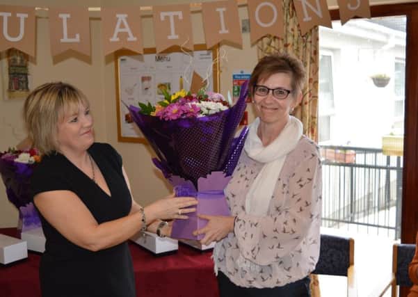 Michelle Doggett (right) receiving flowers after winning the title of Randox Health Healthcare Nurse of the Year. INNT 13-802CON