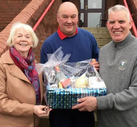 Georgre Baldrick (centre) receives his prize from Lady Captain Frances McLaughlin and Club Captain Clive Brolly.
