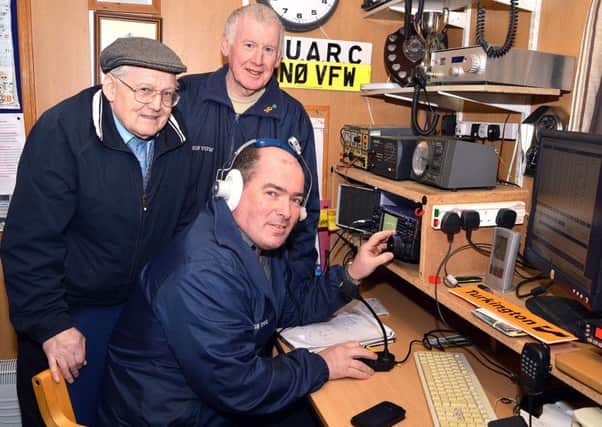 Tuning In...Celebrating 50 years of the Mid-Ulster Amateur Radio Club are members from left, Jimmy Lappin, call sign, GI0OND, club chairman and founder member; John Beattie, call sign, 2I0VGW, and seated front, Brian Burns, call sign, MI0TGO. INPT12-212.