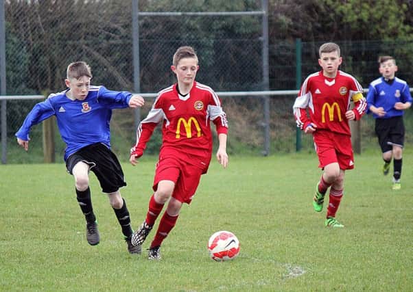 A Carniny Youth under-14 player comes under pressure from a Limavady opponent. INBT 14-819H