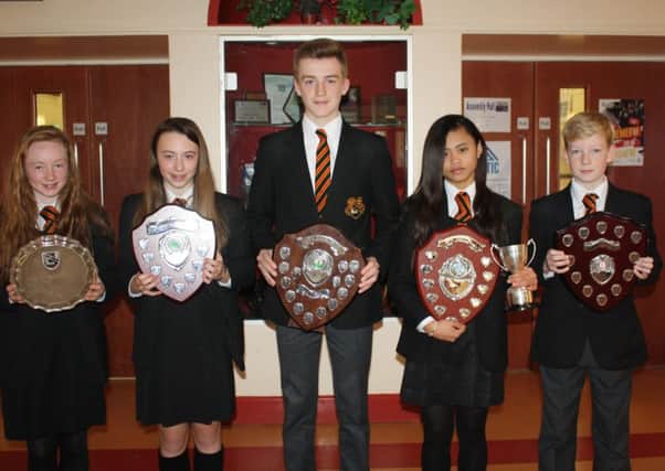 Successful captains from Killicomaine show off some of the silverware lifted during a memorable season. From left are Ashley Neill (hockey), Hannah Reavie (hockey), James Campbell (rugby), Erika Sagayno (netball) and Jamie Donaldson (football).