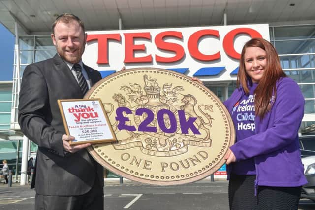 Tesco NI Commercial Manager Sean Largey and Cailin Hardy, NI Children's Hospice praise Ballymoney Tesco's for helping to raise Â£20,000. INBM15-16S