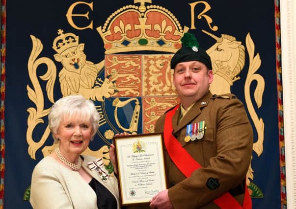 Sergeant Major Instructor John Johnston is pictured receiving  his Lord Lieutenants Certificate for Outstanding Meritorious Service Above and Beyond the Call of Duty from Mrs Joan Christie OBE, Her Majestys Lord Lieutenant for County Antrim. INLT-14-703-con