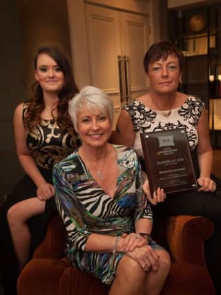 Compere Pamela Ballantine presents the runner up mother and step-daughter housekeeping team award in the under 90 bedroom category to Margaret and Kirbie McClenaghan from the Bushmills Inn Hotel.