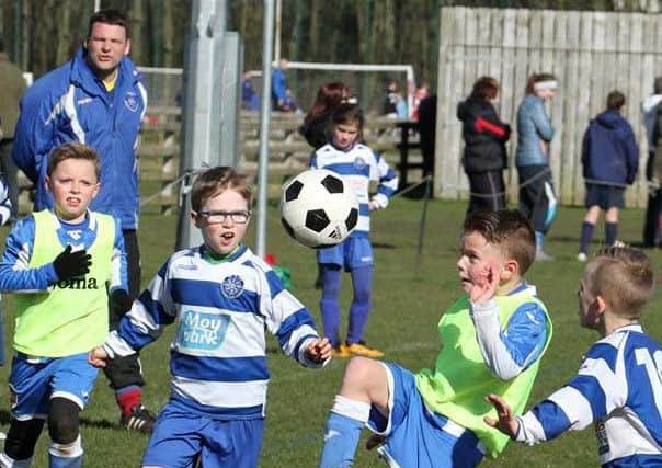 Northend U9s, with Manager Alex McDonald looking on, in action against Coleraine Academy U8s.