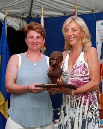 Brenda Preston lifts the Lady Helm Trophy at the GP14 World Championship held at the Barbados Yacht Club in Bridgetown, Barbados.