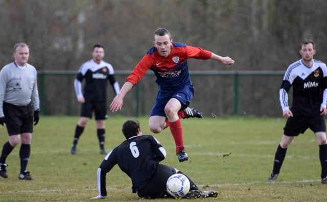 Caw's Mark Campbell hurdles this tackle from Foyle Wanderers Reserves player Lee Kelly. INLS1616-133KM