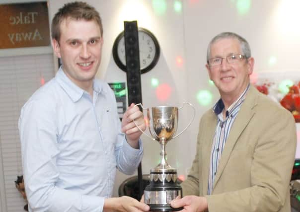 Alex Bell, on behalf of winners Duneane, receives the Antrim & District Churches League trophy from Samuel Gray.