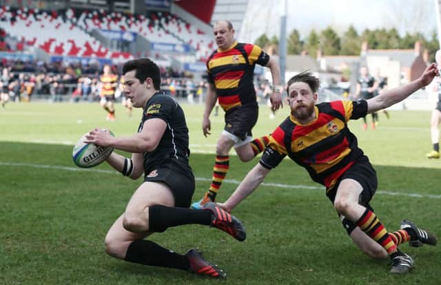 Robert Lamberton scores one of his three tries under pressure from Lurgan's Andrew Stevenson during Saturday's Gordon West Final at Kingspan Stadium.
 (Picture by Brian Little/Presseye)