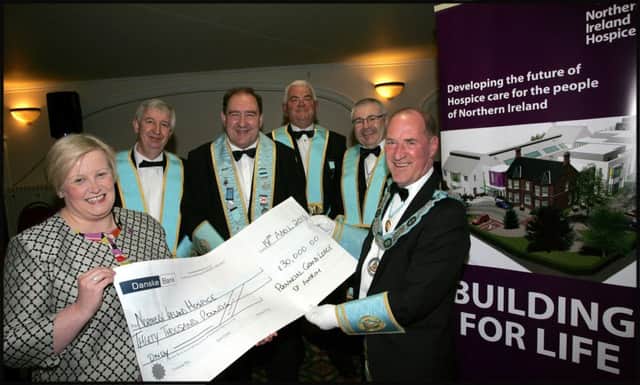 Provincial Deputy Grand Master R.W. Bro David Lyness, chairman of the Antrim Charity Committee, is watched here by members of the Seven Towers Charities Committee W.Bro Tim Coulter, W.Bro George Peden, W.Bro Roy Gilmour and W.Bro Allen Mercer, as he presents a cheque for Â£30,000, on behalf of the Freemasons of Antrim, to Heather Weir, Chief Executive of the N.I. Hospice. The money, which will go towards the Hospice ?Fit Out? appeal to equip bedrooms in the new hospice, was presented during the Provincial Grand Lodge of Antrim Stated Communication, which was held in the Leighinmohr House Hotel Ballymena on Monday evening.