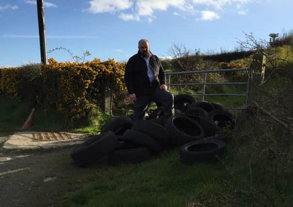 Cllr Mark Baxter with dumped tyres