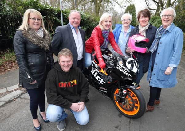 Road racer Davy Morgan (front) and Mark Harrison, from Road Racing Supporters Club, and their 200mph 1,000cc superbike, pictured with members of the Upfront Breast Cancer Support Group, from left, Sally Harrison, Nicki Ingram, Jean Campbell, Olwyn Millar and Sandra McDowell. Road Racing Supporters Club has raised thousands of pounds over recent years for the Upfront. US1616-501cd  Picture: Cliff Donaldson