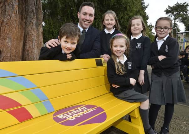 Paddy Wallace delivers the first 'Buddy Bench' to Whiteabbey Primary School. He is pictured with pupils Matthew McCabe (6), Eva Wilson (9), Darcy Wilson (7), Evie Wright (7) and Katie McCabe (5). INNT 16-540CON