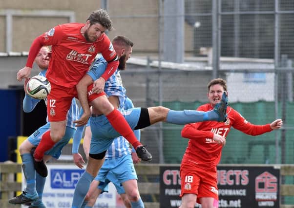 Ken Oman in a physical aerial battle as Gary Twigg looks on during Portadown's weekend defeat by Warrenpoint Town. Pics by PressEye Ltd.