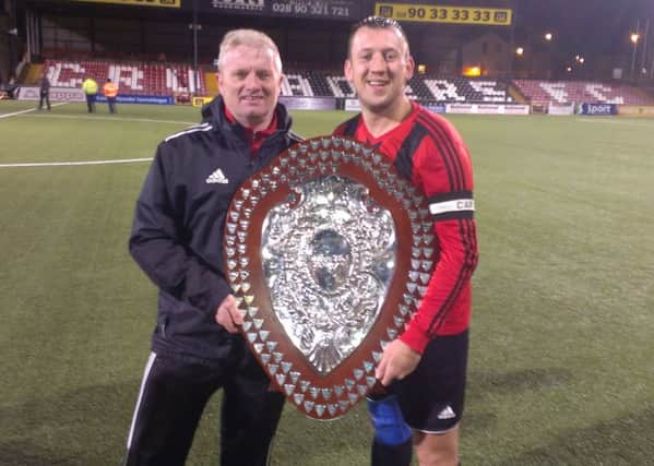 Harryville Homers manager Robert Duddy and captain Gary Bonnes celebrate the club's County Antrim Junior Shield success.