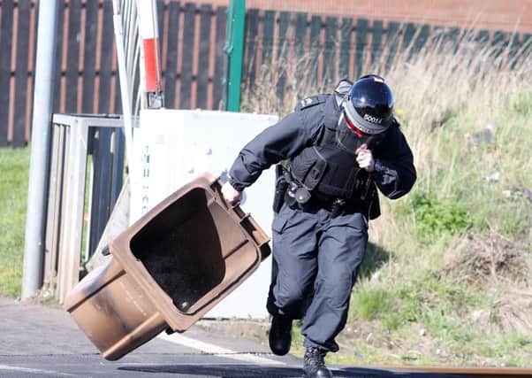 Press Eye - Belfast - Northern Ireland - 28th March 2016

Trouble starts in the Lake Street area of Lurgan as nationalist youths throw stones at police and set a wheelie bun on fire on the railway line.  A PSNI officer removes the bin from the tracks. 

Picture by Jonathan Porter/PressEye