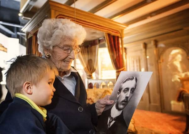 Eleanor Thompson with her great-grandson looking at a photo of her father, Ambrose Willis.  INLT 18-653-CON