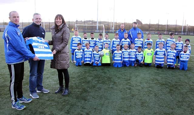 Joanne Croskery (Financial Director) presents Northend United 2008/2009 squad with a new kit sponsored by JBE Mechanical Electricial to coach John Devlin with  Connor Croskery looking on. INBT 19-802H