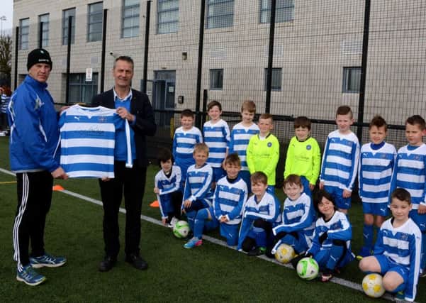 Gary O'Loughlan, of Laragh Lodge, presentsÂ  John Devlin and the players of Northend United Youth 07's Football Development Centre with a new kit.