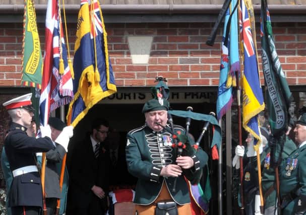 A piper and standard bearers pay tribute to Mr Hamilton at the church. INCT 19-200-AM
