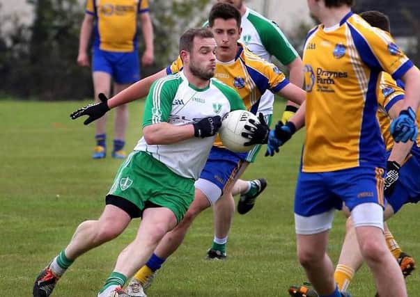 St Comgall's Paddy Quinn received plenty of attention on his way to score.