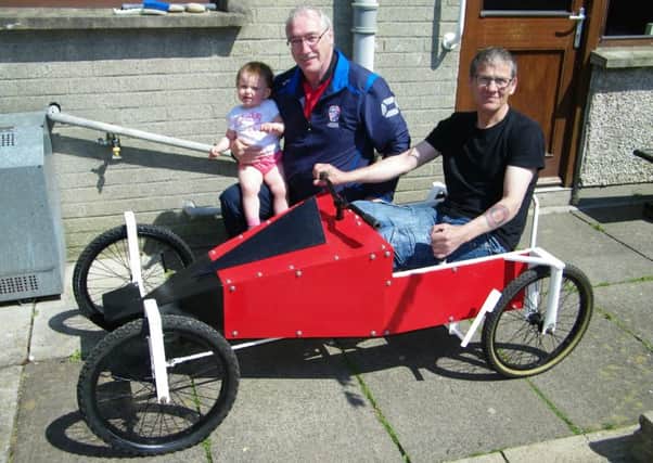 Soapbox team: Kevin McCrudden with granddaughter Kacey and (seated) Robin Lynn who designed and made the kart.