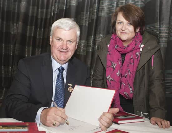 SIGN. President of the GAA AogÃ¡n " Fearghail, pictured signing a book at the launch to mark Loughguile Shamrocks GAA Centenary year for Claire Kelly in the Millennium Centre on Fri night.INBM21-16 016SC.