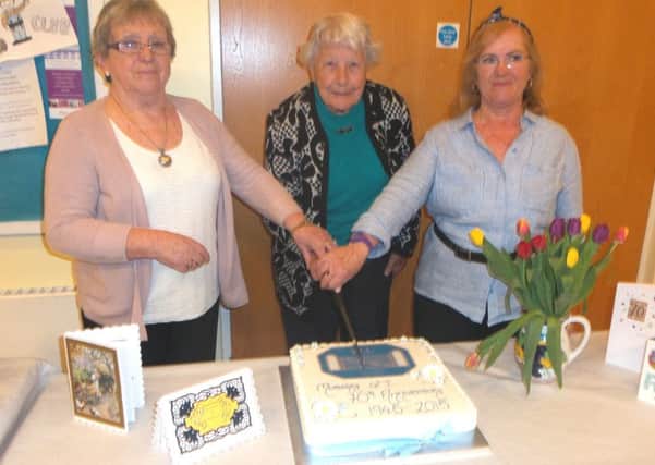 Celicia McCalmont, Dorothy Auld and Jennifer Cosgrove cut the 70th anniversary cake. INNT 21-515CON