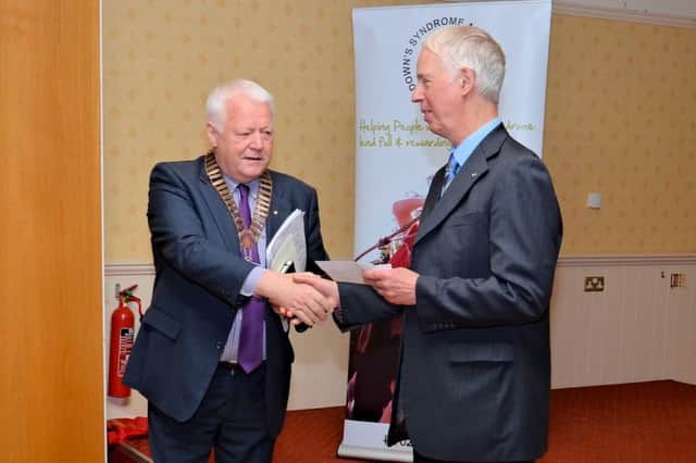 Alan Bennett, volunteer with the Downs Syndrome Association, is presented with a cheque by Freddie Hall, Past President of Lisburn Probus Club