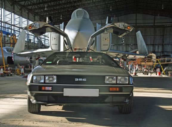 Wings and things:   The distinctive gull-wing doors of a DeLorean are mimicked in this photo by the folding wingtips of a massive Phantom jet fighter in the hangar of the Ulster Aviation Society at the Maze/Long Kesh site.