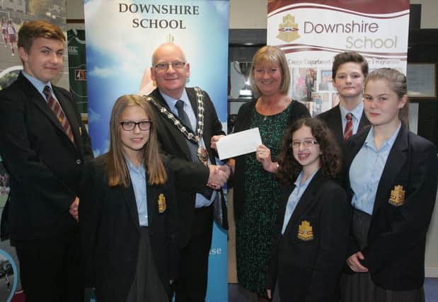 Pupils from Downshire School look on as the Mayor of Mid and East Antrim, Councillor Billy Ashe is presented with a cheque for Â£350 for the Alzheimers Society by principal Jacqueline Stewart. The money was raised on a non-uniform day on  April 29, which was also Inter-Generational Day, to support the mayors chosen charity. INCT 22-705-CON