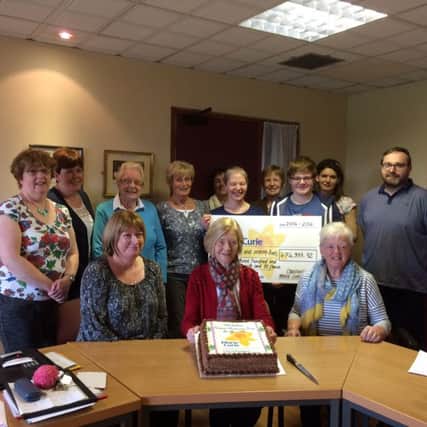 Members of the Craigavon Marie Curie fundraising group with their anniversary cake. INPT22-017