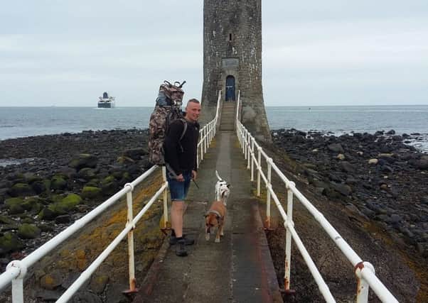 Richard Lynn with his two Staffordshire Bull Terriers Fudge and Benji at Larne's Chaine Memorial Tower.  INLT 22-653-CON