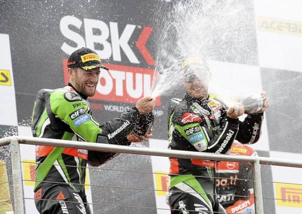 Tom Sykes and Jonathan Rea (right) spray champagne on the podium. INLT 22-917-CON