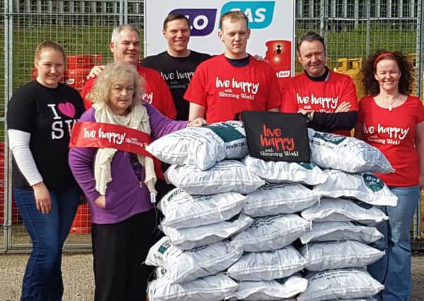 Larne Slimming World group leaders and their groups' greatest losers survey the equivalent weight they lost in bags of coal. INLT-23-700-con