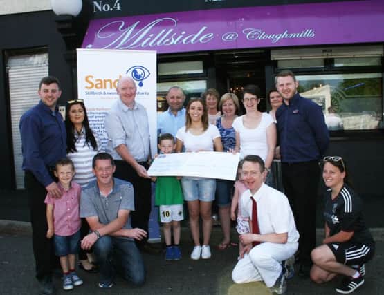 Nicola Lorimer presents a cheque for Â£7,450 to Steven Guy the Network Co-ordinator for SANDS in Northern Ireland and Claire Charles, from SANDS, Antrim, at the Millside Restaurant, Cloughmills, on Monday. Nicola and her many friends raised the money from taking part in the Belfast marathon some of whom are included in the picture. INBM25-16S