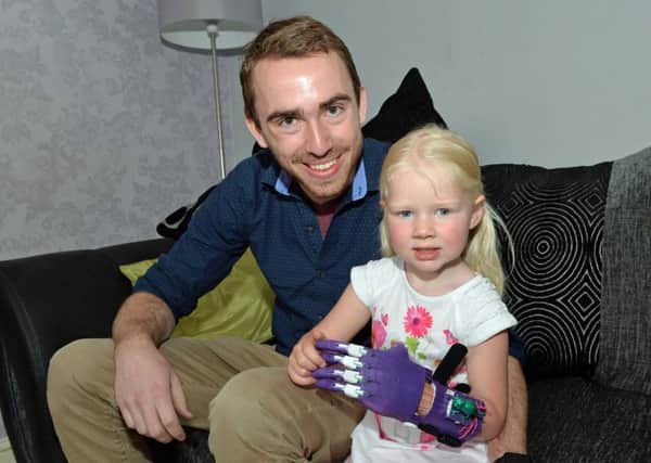 Student Craig Kelly from e-NABLE with Lillie McGregor and her new 3D printed hand