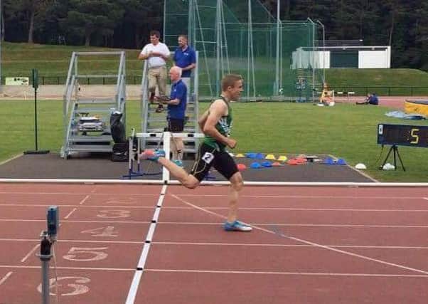 Adam Neilly crosses the line to win the 400 metres.