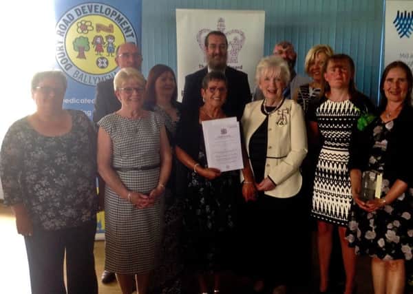 Lord Lieutenant of County Antrim Mrs Joan Christie OBE presents  the Queens award for Voluntary Service to members of the Doury Road Development Group. (Submitted Picture).