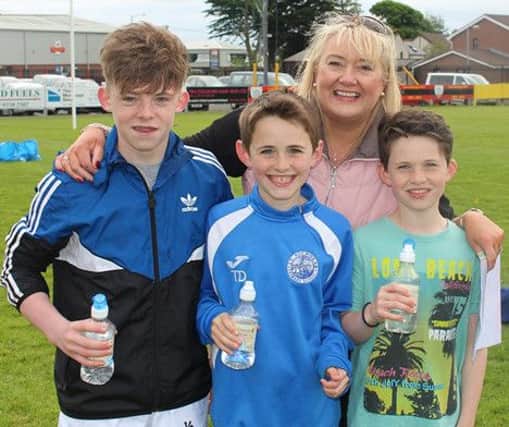 Michael Wilson, Ruairi Devine, Tiarnan Devine and teacher Claire Byrne on sports day at St Nicholas' Primary School, Carrickfergus. INCT 25-702-CON