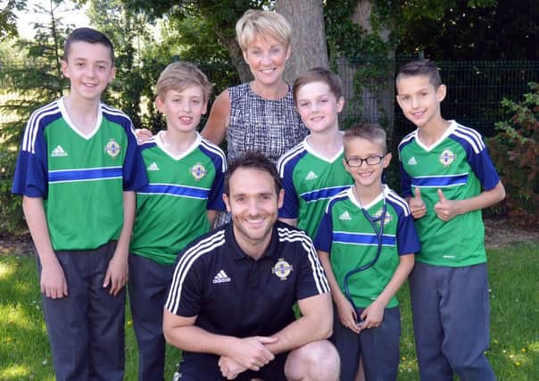 Northern Ireland football team doctor, Dr Ian Ferguson paid a visit to Derryhale Primary School last week. He is pictured here with school prinipal, Mrs Joan McMenemy and pupils from left, Ross Moffett, William Cairns, Tommy McCallen, Harry Whittle and louis Wilson. INPT26-201.