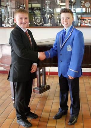 Old meets new: Pupils of St John the Baptist Primary School compare their old and new uniforms.