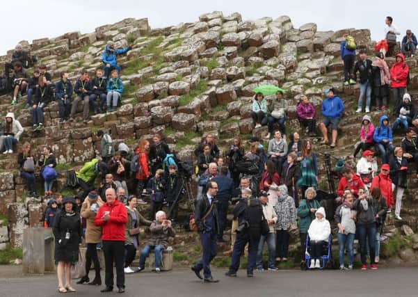 Tourists await the arrival of the Queen Elizabeth II and the Duke of Edinburgh to the Giant's Causeway on the Co Antrim coast during the second day of her visit to Northern Ireland to mark her 90th birthday. PRESS ASSOCIATION Photo. Picture date: Tuesday June 28, 2016. See PA story ROYAL Ulster. Photo credit should read: Niall Carson/PA Wire