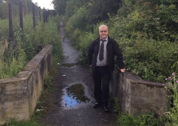 Sinn Fein Cllr Liam Mackle at a notorious black path in Taghnevan which is set to be sealed off