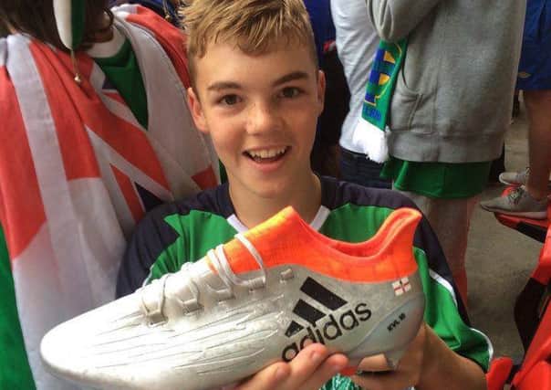 An ecstatic Cameron Lindsay clutches Kyle Lafferty's Euro 2016 boot. INNT-27-701-con