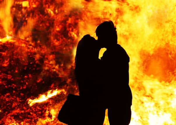 Burning love - A couple embrace beside an 11th July bonfire at Ballymacash, Lisburn