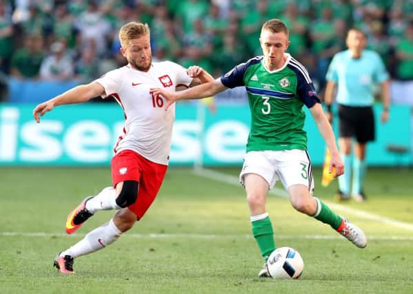Northern Ireland's Shane Ferguson holds off Poland's Jakub Blaszcykowski during their opening Euro 2016, Group C match at the Stade de Nice. Picture by William Cherry