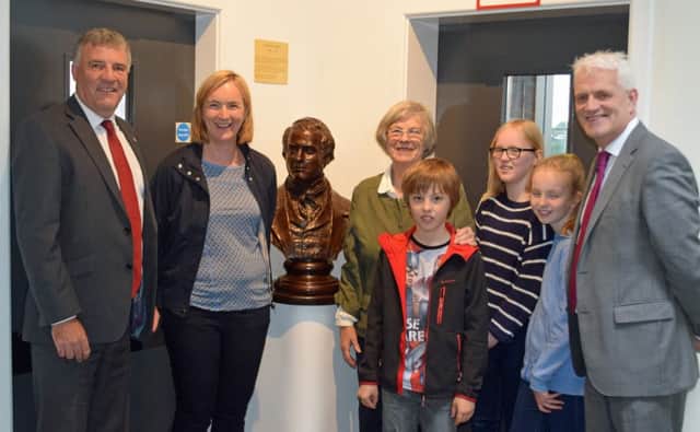 James McKervill (Chairman of the Board Of Governors, Ballymena Academy), Heather Bothwell, Laura Noble,. Jean Noble,
Fergus Emmett, Alice Emmett, Tara Emmett (grandchildren) and Stephen Black (Principal) with the sculpture of Darwin presented to the school in celebration of the life and work of former Academy teacher, Frank Noble by his wife. (Submitted Picture)