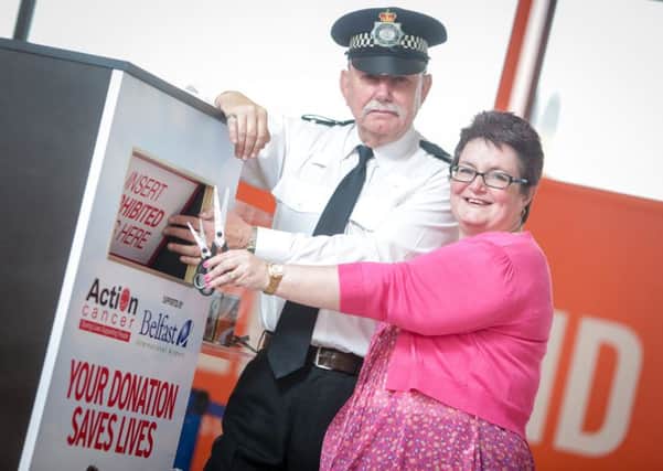 Police Sergeant, Jim Reynolds pictured with Action Cancer Ambassador Janet Gaw in front of the new sharps box positioned at the security area at Belfast International Airport.