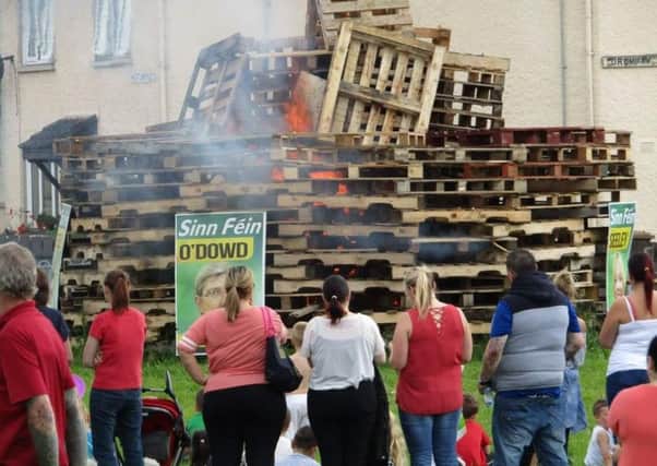 Children and adults watch as Sinn Fein posters burned at loyalist bonfire in Portadown